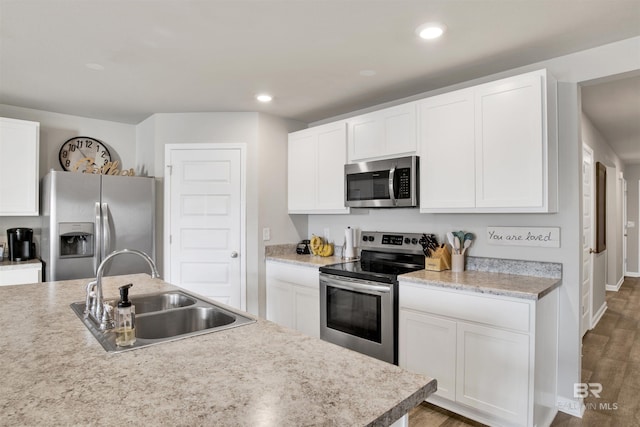 kitchen with sink, dark hardwood / wood-style floors, white cabinets, and appliances with stainless steel finishes