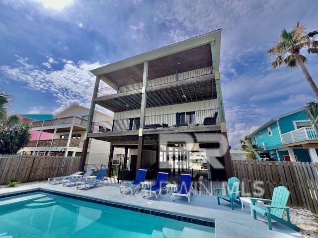 back of house featuring a fenced in pool, a balcony, and a patio