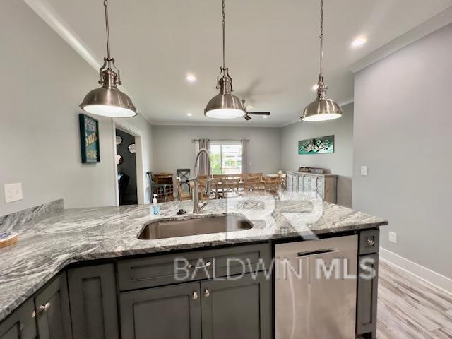 kitchen featuring light wood-type flooring, gray cabinets, light stone counters, and sink