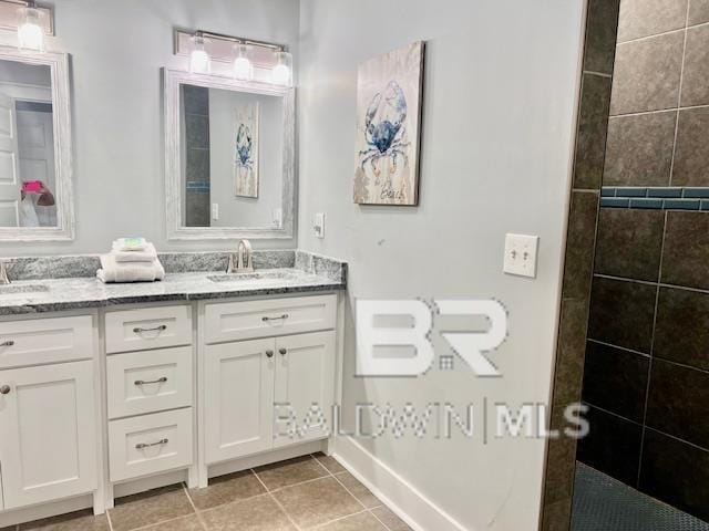 bathroom featuring tile patterned floors, vanity, and a tile shower