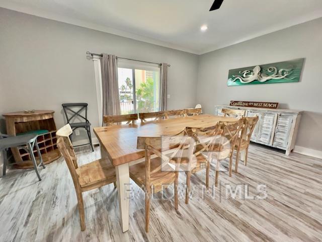 dining space with light wood-type flooring and ceiling fan