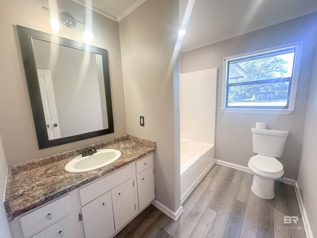 bathroom with baseboards, vanity, toilet, and wood finished floors