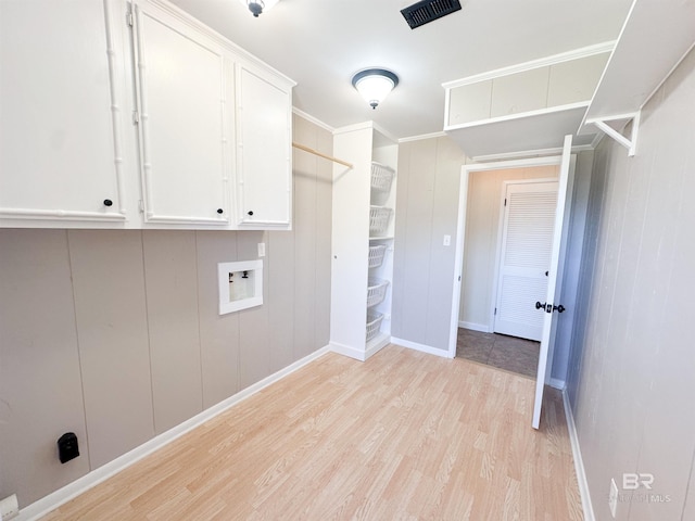 laundry area featuring hookup for a washing machine, visible vents, baseboards, light wood-style floors, and cabinet space