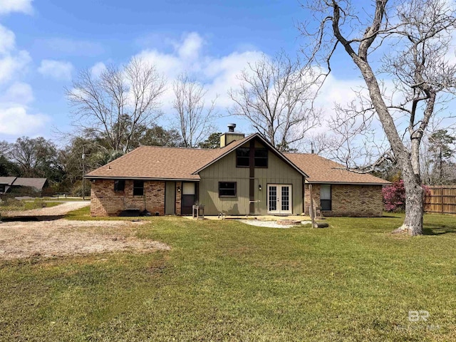 1104 N Pine St, Foley, AL 36535 - view of front of house with brick siding, fence, a front yard, french doors, and a chimney