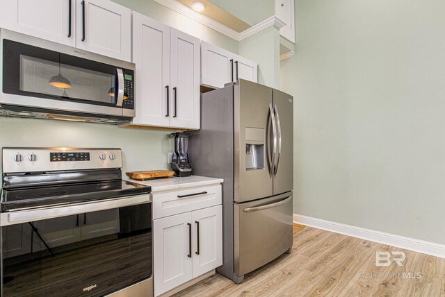 17290 Perdido Key Dr Unit 5B, Pensacola, FL 32507 - kitchen featuring stainless steel appliances, light countertops, light wood-style flooring, and baseboards