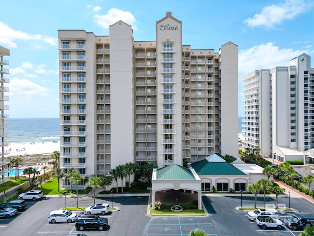 view of building exterior with a water view and uncovered parking