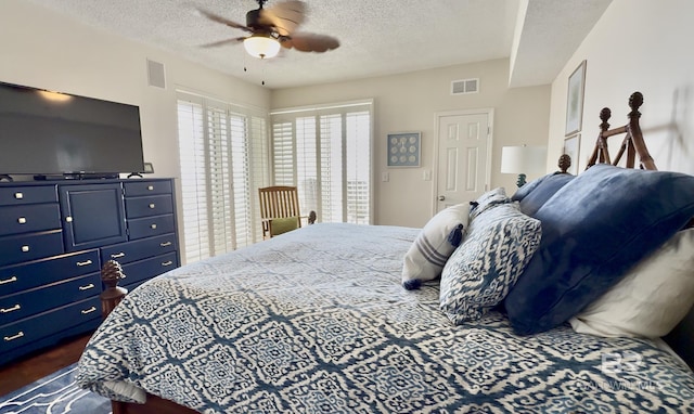 bedroom with a ceiling fan, a textured ceiling, and visible vents