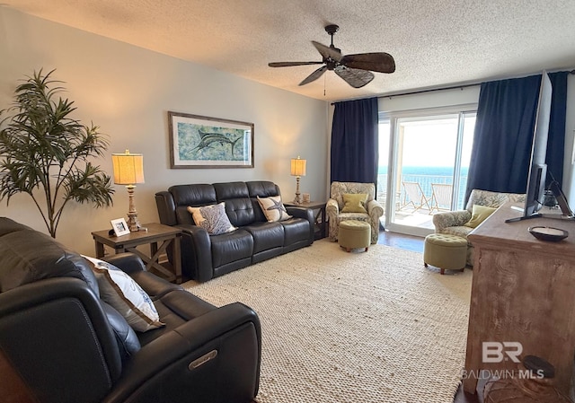 living area with a textured ceiling and ceiling fan