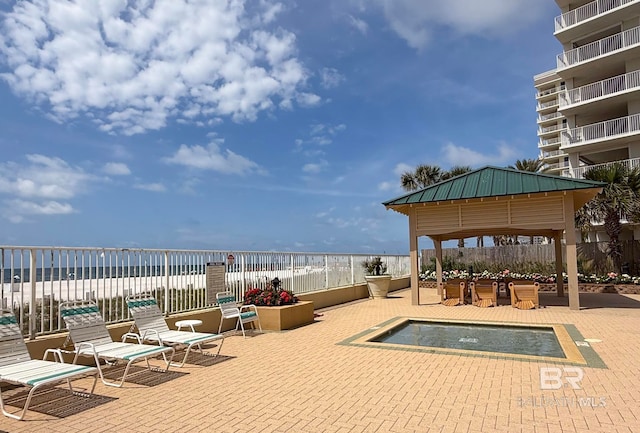 view of patio with a water view, fence, and a gazebo