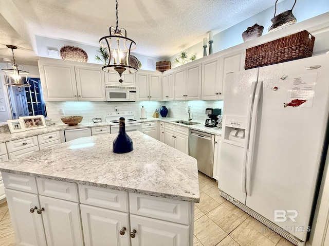 kitchen with white appliances, a textured ceiling, a sink, and white cabinets