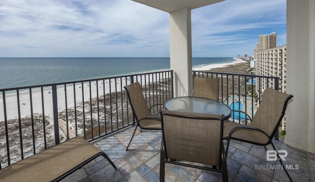 balcony featuring a beach view and a water view