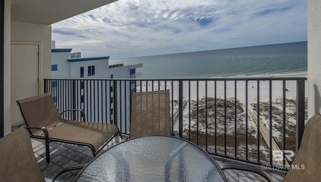 balcony featuring a view of the beach and a water view