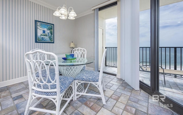 dining space with an inviting chandelier, ornamental molding, and a water view