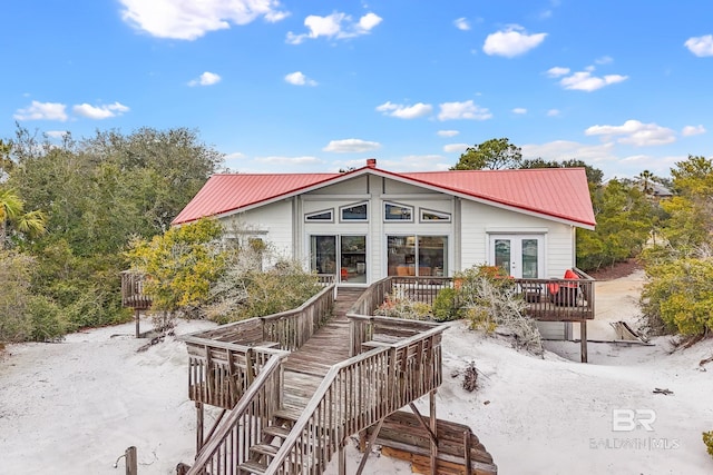 back of house with a deck, french doors, metal roof, and stairway