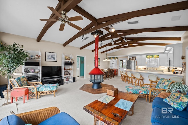 living room featuring lofted ceiling with beams, visible vents, a ceiling fan, and light colored carpet