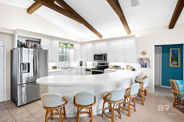 kitchen with appliances with stainless steel finishes, white cabinets, light countertops, and visible vents