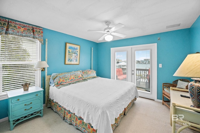 bedroom featuring light carpet, access to outside, multiple windows, and visible vents