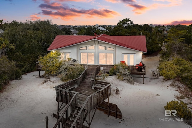 back of property at dusk featuring metal roof