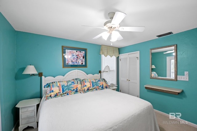 carpeted bedroom featuring a ceiling fan, a closet, visible vents, and baseboards