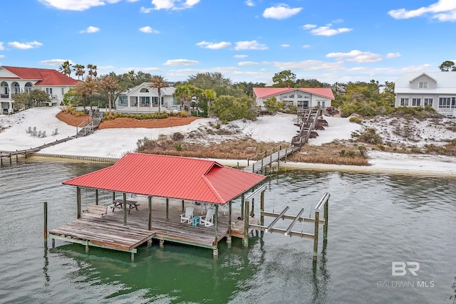 view of dock with a water view, boat lift, and a residential view