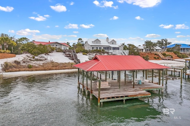 view of dock with a water view, boat lift, and a residential view