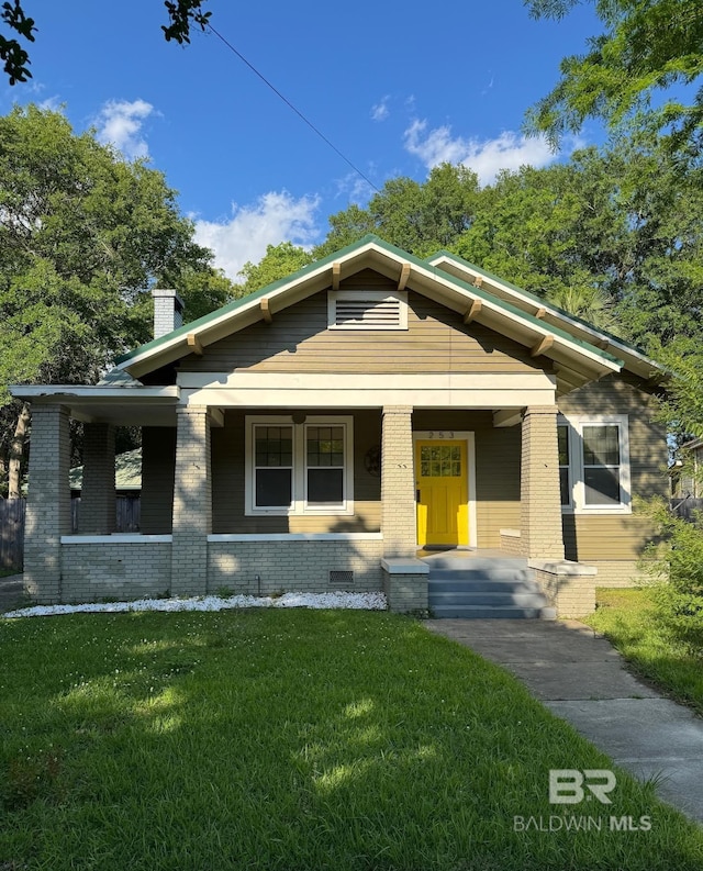 253 Cherokee St, Mobile, AL 36606 - view of front of property with a front lawn, brick siding, a chimney, and a porch