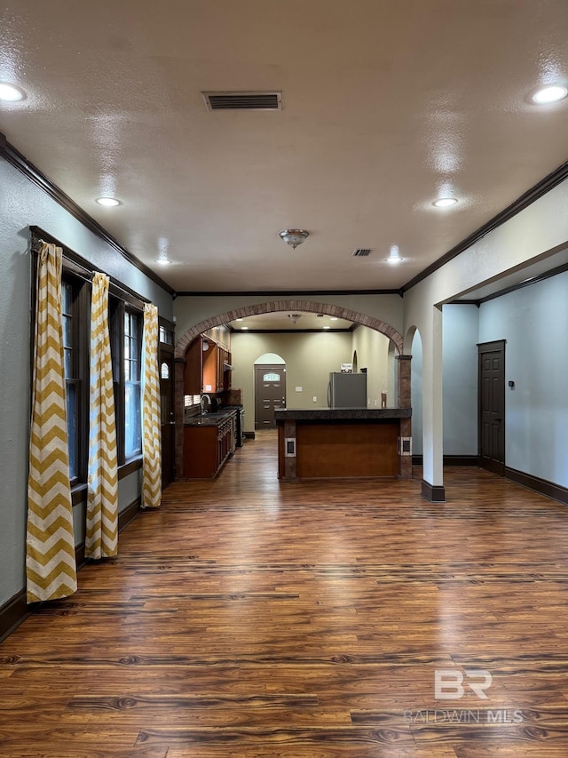 253 Cherokee St, Mobile, AL 36606 - unfurnished living room featuring arched walkways, ornamental molding, dark wood-style flooring, baseboards, and recessed lighting