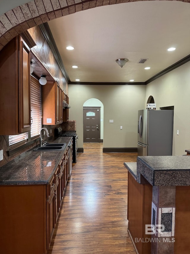 253 Cherokee St, Mobile, AL 36606 - kitchen with stainless steel appliances, a sink, arched walkways, dark wood-type flooring, and crown molding