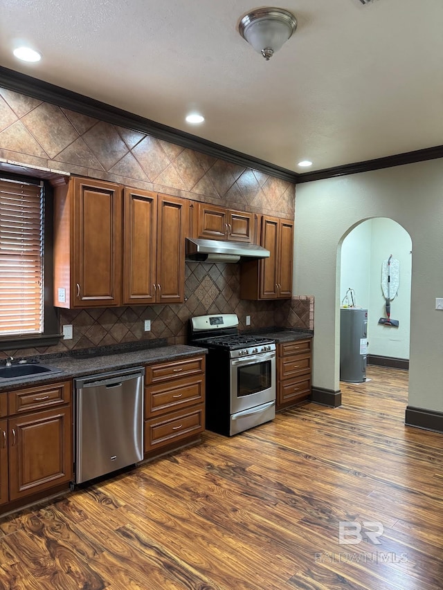253 Cherokee St, Mobile, AL 36606 - kitchen featuring stainless steel appliances, dark countertops, arched walkways, ornamental molding, and decorative backsplash