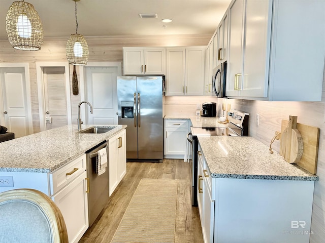 kitchen with white cabinetry, appliances with stainless steel finishes, sink, and pendant lighting