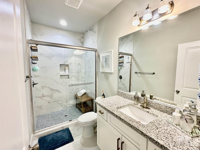 bathroom featuring vanity, toilet, and a shower with shower door