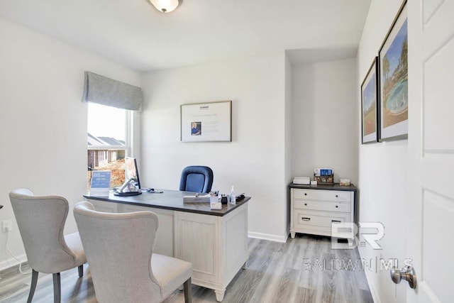 office space with light wood-type flooring and baseboards