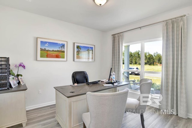 office space with light wood-type flooring and baseboards