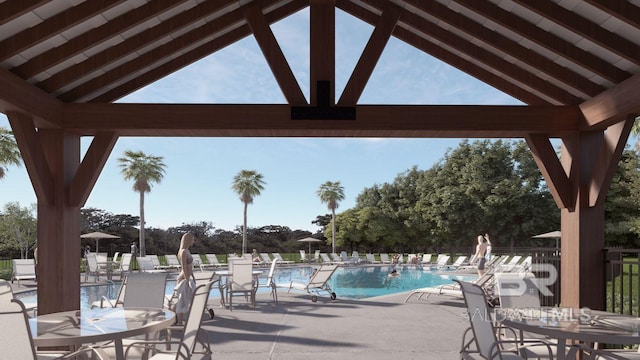 view of patio / terrace with a community pool, fence, and outdoor dining space