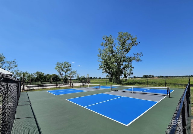 view of tennis court featuring community basketball court and fence