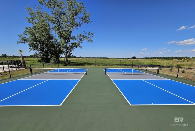 view of sport court featuring community basketball court, a rural view, and fence