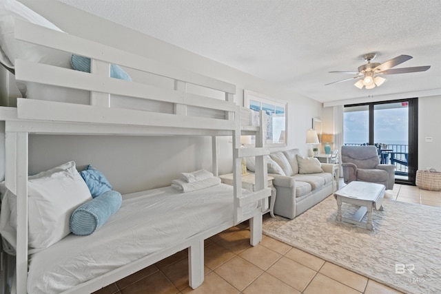26802 Perdido Beach Blvd Unit 7C2, Orange Beach, AL 36561 - bedroom with light tile patterned floors, a ceiling fan, a textured ceiling, and access to exterior