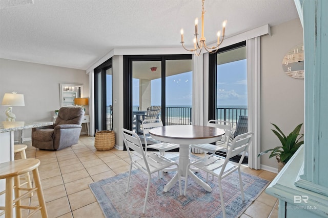 26802 Perdido Beach Blvd Unit 7C2, Orange Beach, AL 36561 - dining area featuring a water view, a textured ceiling, an inviting chandelier, and light tile patterned floors