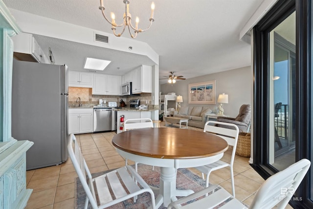 26802 Perdido Beach Blvd Unit 7C2, Orange Beach, AL 36561 - dining room with light tile patterned floors, ceiling fan with notable chandelier, a textured ceiling, and visible vents