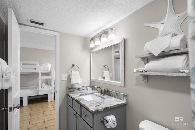 26802 Perdido Beach Blvd Unit 7C2, Orange Beach, AL 36561 - ensuite bathroom with toilet, a textured ceiling, visible vents, and vanity