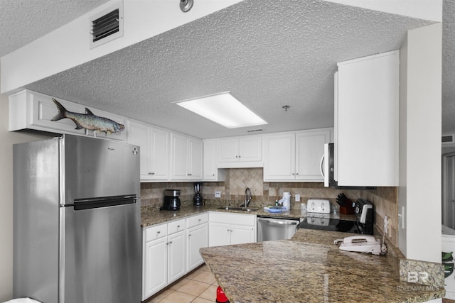 26802 Perdido Beach Blvd Unit 7C2, Orange Beach, AL 36561 - kitchen featuring appliances with stainless steel finishes, white cabinets, a textured ceiling, and visible vents