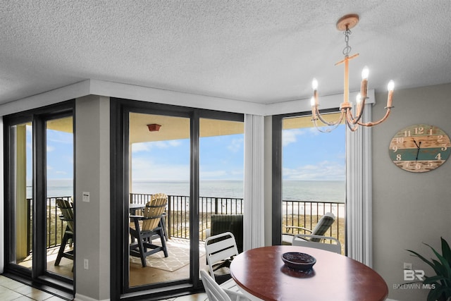 26802 Perdido Beach Blvd Unit 7C2, Orange Beach, AL 36561 - dining area featuring a water view, a textured ceiling, and a notable chandelier