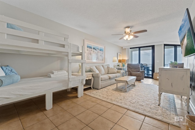 26802 Perdido Beach Blvd Unit 7C2, Orange Beach, AL 36561 - tiled bedroom featuring access to outside, a ceiling fan, and a textured ceiling