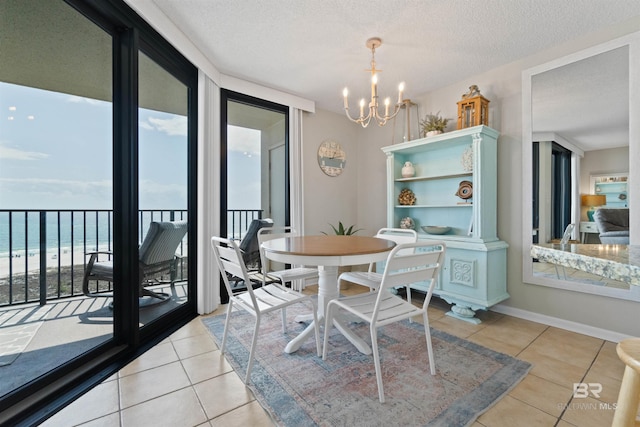 26802 Perdido Beach Blvd Unit 7C2, Orange Beach, AL 36561 - dining space featuring baseboards, a textured ceiling, light tile patterned floors, and a chandelier