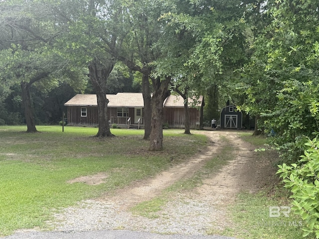 13448 Cripple Creek Ln, Lillian, AL 36549 - single story home featuring dirt driveway, a shed, a front yard, and covered porch
