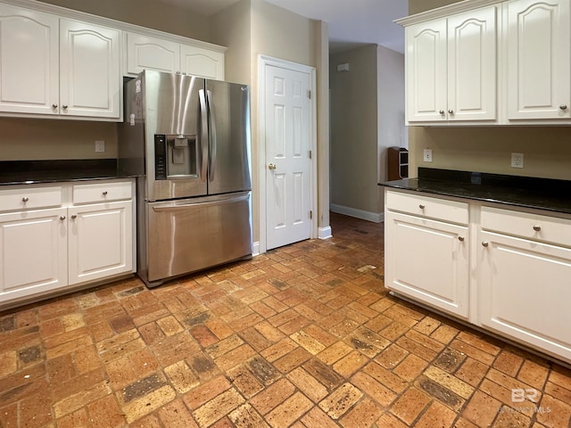 kitchen featuring white cabinets and stainless steel fridge