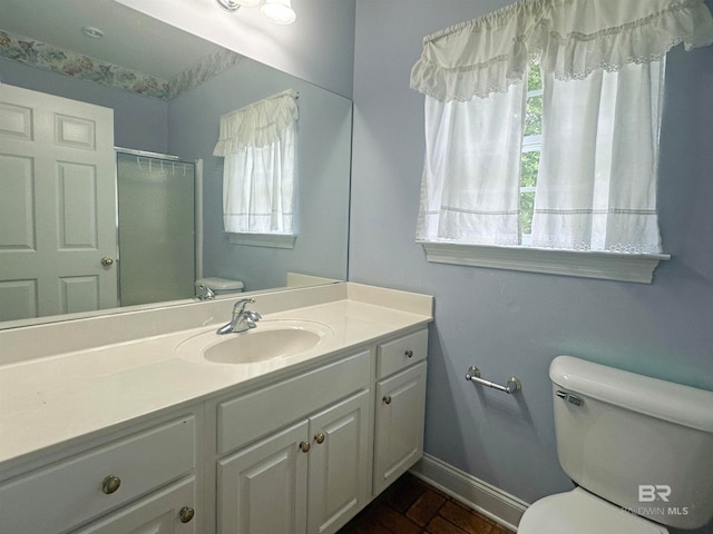 bathroom with a wealth of natural light, vanity, toilet, and tile floors