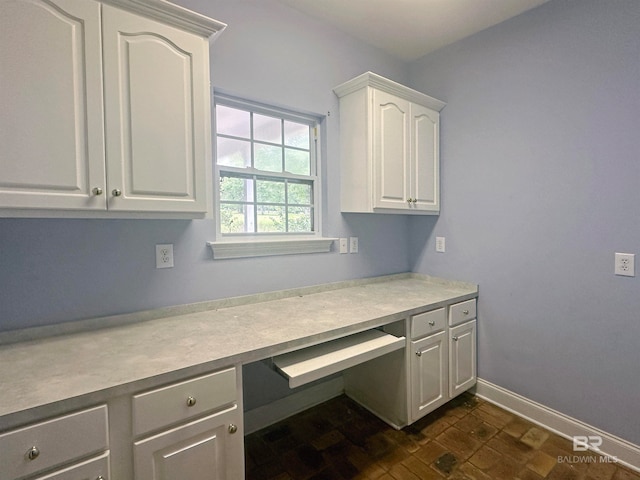 kitchen featuring built in desk and white cabinetry