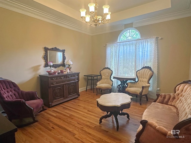 living room with a notable chandelier, a raised ceiling, crown molding, and wood-type flooring