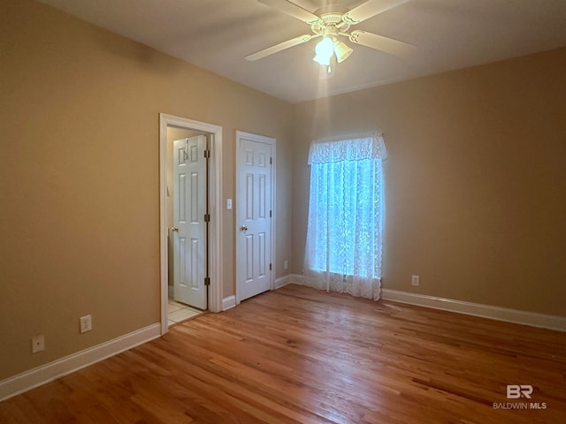 empty room with light wood-type flooring and ceiling fan